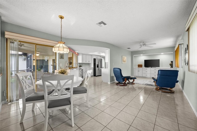 tiled dining space featuring ceiling fan and a textured ceiling