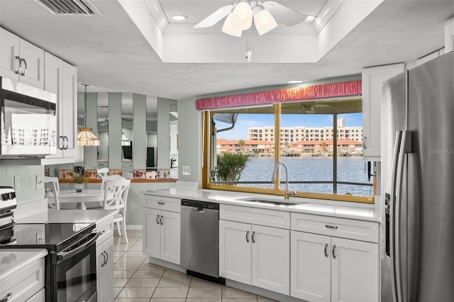 kitchen featuring appliances with stainless steel finishes, white cabinetry, a raised ceiling, and sink