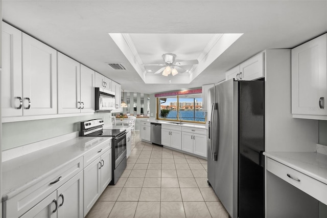 kitchen with sink, stainless steel appliances, crown molding, a tray ceiling, and white cabinets