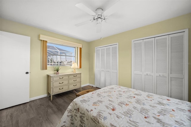 bedroom featuring ceiling fan, dark hardwood / wood-style floors, and two closets