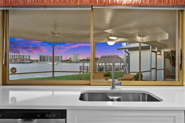 kitchen with white cabinets, dishwasher, a water view, and sink