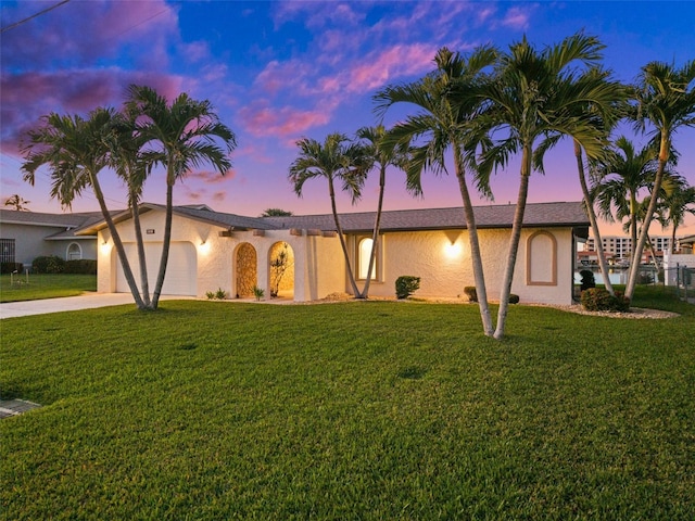 view of front of home featuring a garage and a lawn