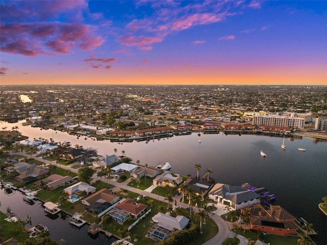 aerial view at dusk featuring a water view