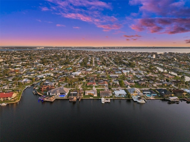 aerial view at dusk featuring a water view