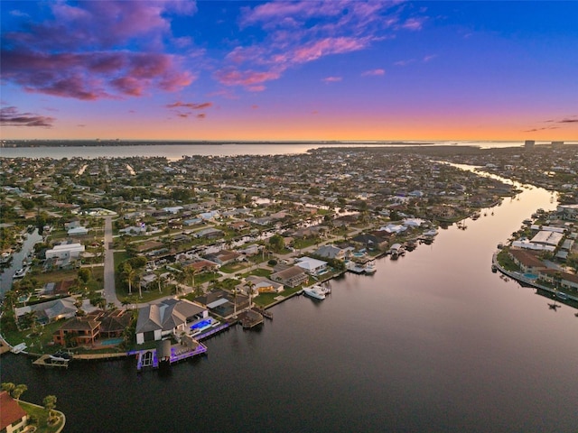 aerial view at dusk featuring a water view