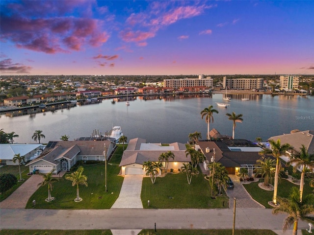 aerial view at dusk featuring a water view