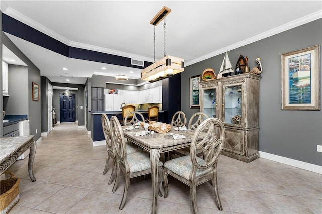 dining room featuring baseboards, ornamental molding, and light tile patterned flooring