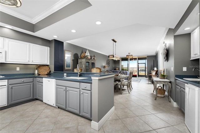 kitchen with dark countertops, gray cabinetry, open floor plan, white dishwasher, and a sink