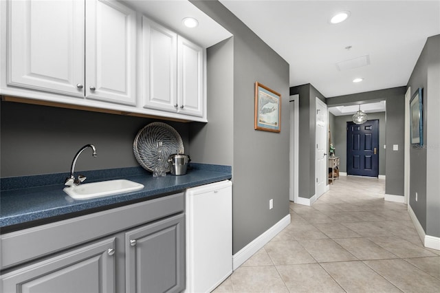 interior space with recessed lighting, a sink, baseboards, and light tile patterned floors