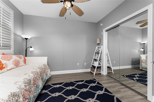 bedroom featuring ceiling fan, baseboards, dark wood finished floors, and a closet