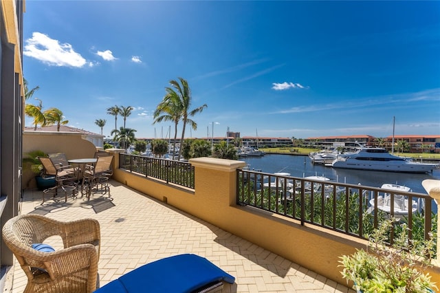 view of patio with a water view and a balcony