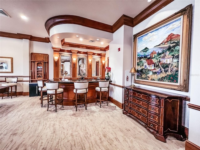 bar with baseboards, indoor wet bar, visible vents, and crown molding