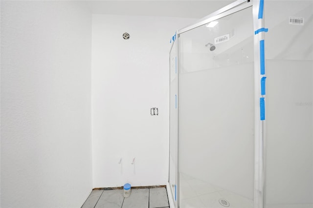 bathroom featuring tile patterned floors and a shower with door