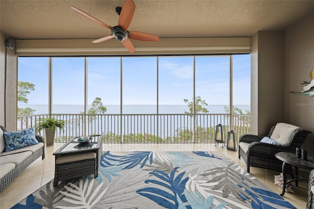 sunroom featuring a water view and ceiling fan