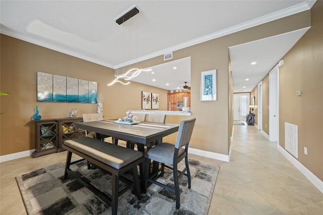 tiled dining room featuring crown molding