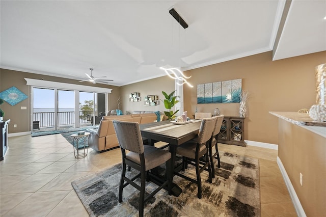 tiled dining room with ceiling fan and crown molding