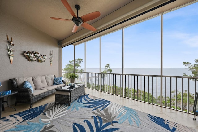 sunroom / solarium with ceiling fan, a water view, and lofted ceiling