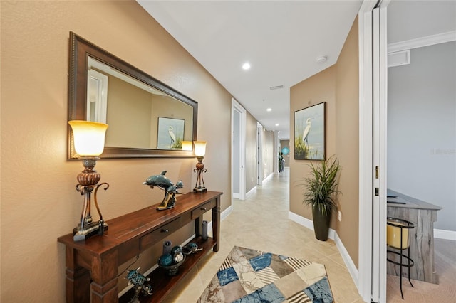 hall featuring light tile patterned flooring and ornamental molding