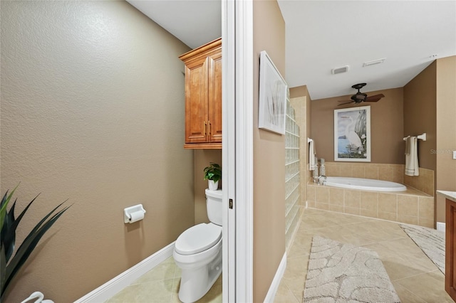 bathroom featuring tile patterned flooring, toilet, ceiling fan, and tiled tub