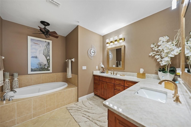 bathroom with tile patterned flooring, vanity, ceiling fan, and tiled tub