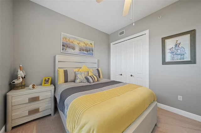 bedroom featuring ceiling fan, light carpet, and a closet