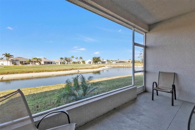 unfurnished sunroom featuring a water view