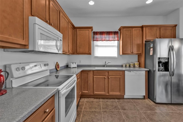 kitchen featuring sink, dark tile patterned floors, and white appliances