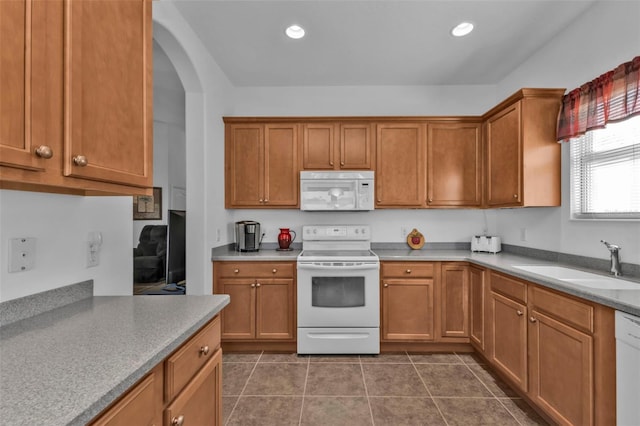 kitchen featuring white appliances, dark tile patterned flooring, and sink