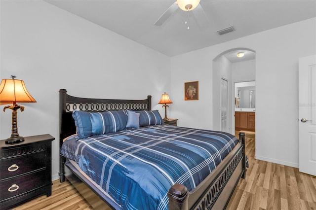 bedroom with ceiling fan, light hardwood / wood-style floors, and connected bathroom