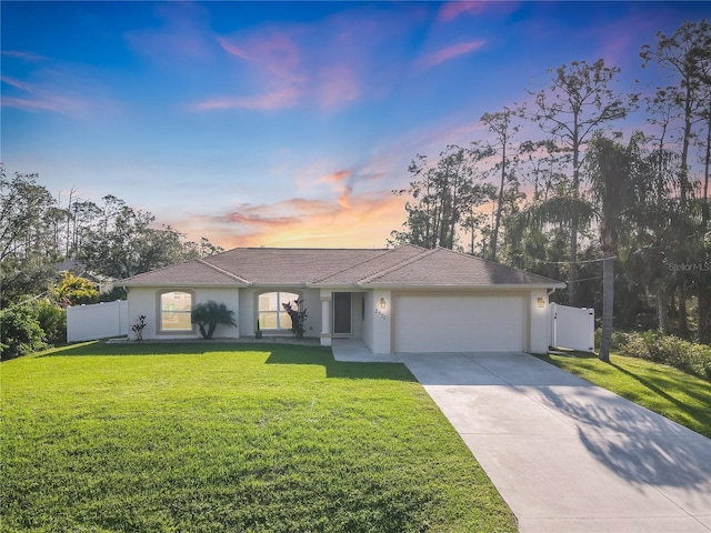 ranch-style house featuring a yard and a garage