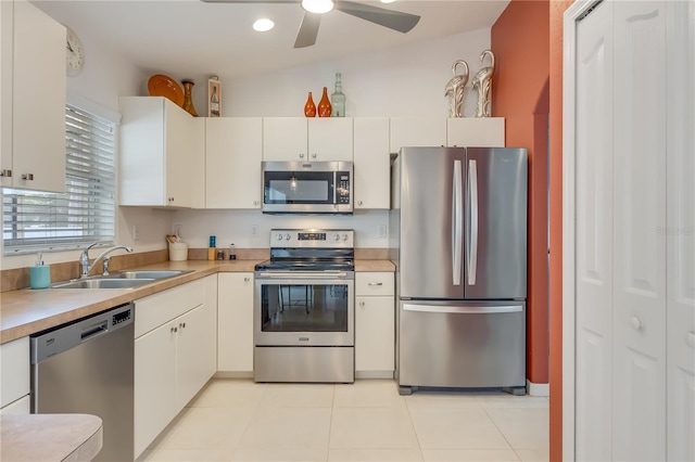 kitchen with appliances with stainless steel finishes, vaulted ceiling, ceiling fan, sink, and white cabinets