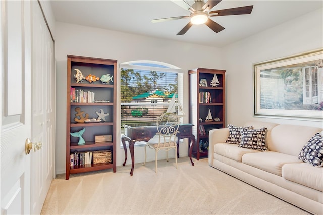 living area featuring ceiling fan and light colored carpet