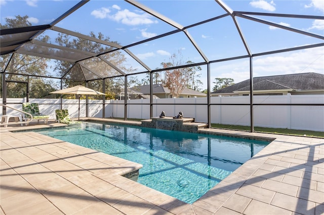 view of swimming pool with pool water feature, a patio area, and a lanai