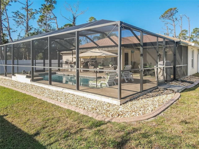 back of house featuring a lawn, a patio area, a lanai, and a fenced in pool