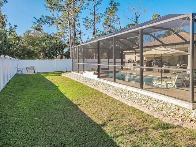 view of yard featuring a fenced in pool and glass enclosure