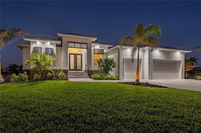 contemporary house with a garage, french doors, and a lawn