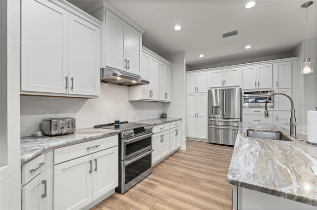 kitchen with pendant lighting, sink, appliances with stainless steel finishes, white cabinetry, and light stone countertops