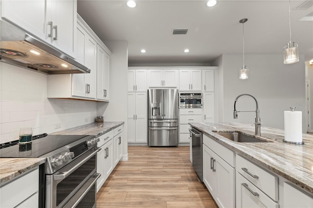 kitchen with pendant lighting, sink, stainless steel appliances, light stone counters, and white cabinets