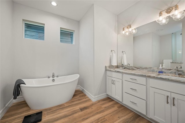 bathroom with vanity, hardwood / wood-style floors, and a washtub