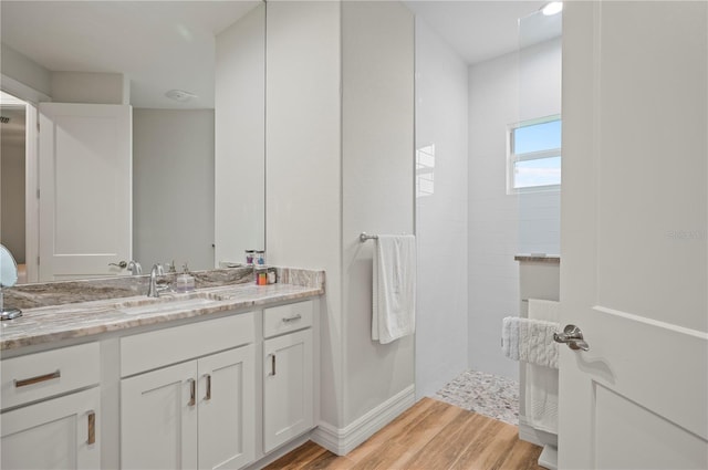 bathroom featuring vanity, hardwood / wood-style flooring, and tiled shower