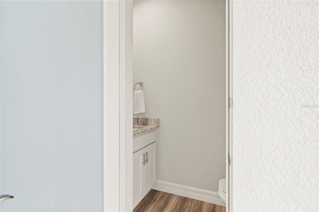 bathroom featuring hardwood / wood-style flooring, vanity, and toilet