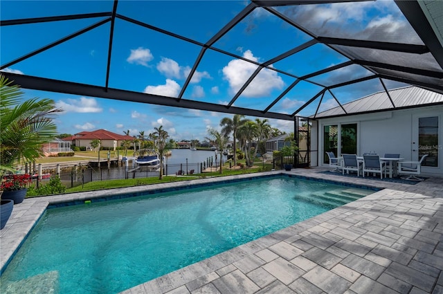 view of swimming pool featuring a water view, a patio area, and a lanai