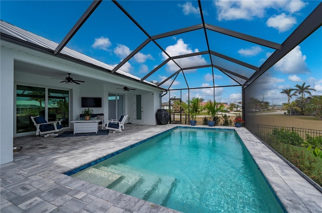 view of pool with a patio area, ceiling fan, and glass enclosure