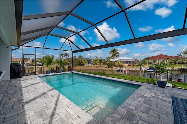 view of pool with a water view, grilling area, a patio, and glass enclosure