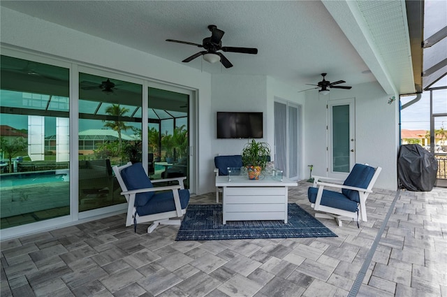 view of patio with ceiling fan, grilling area, and a lanai