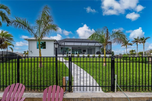 view of gate featuring a yard and glass enclosure