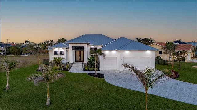 view of front of home featuring a garage and a yard