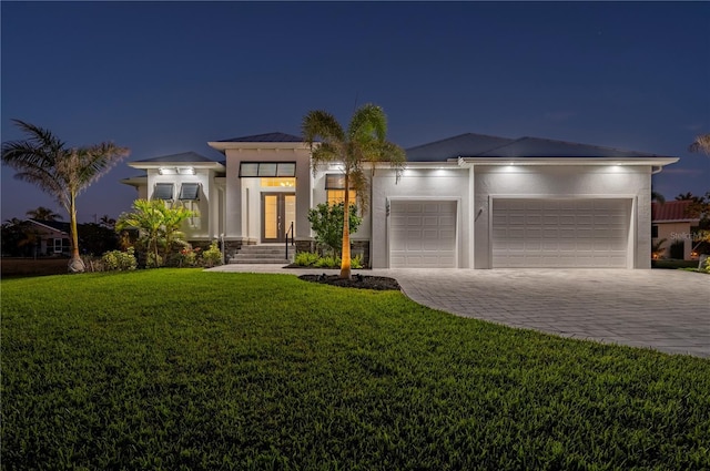 view of front of home featuring a garage and a yard