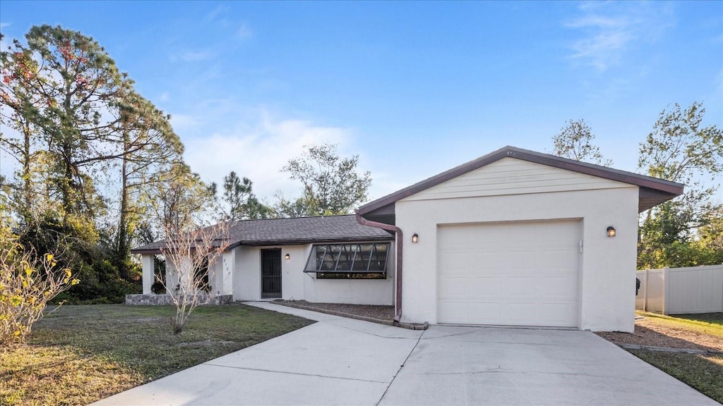 ranch-style home featuring a front yard and a garage