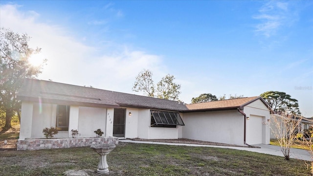 ranch-style home with a front yard and a garage